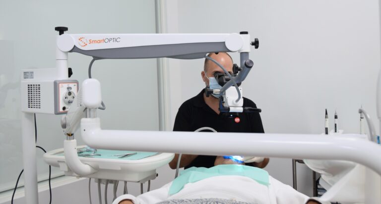 Dentista a utilizar equipamento dentário com máscara de proteção