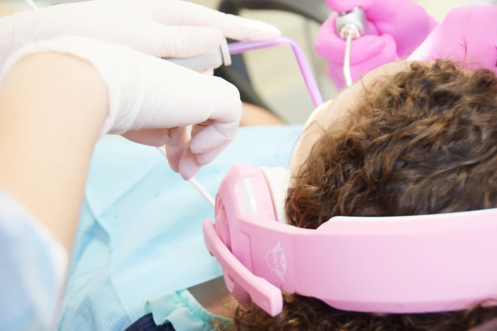 Dentista a realizar procedimento dentário em paciente infantil.