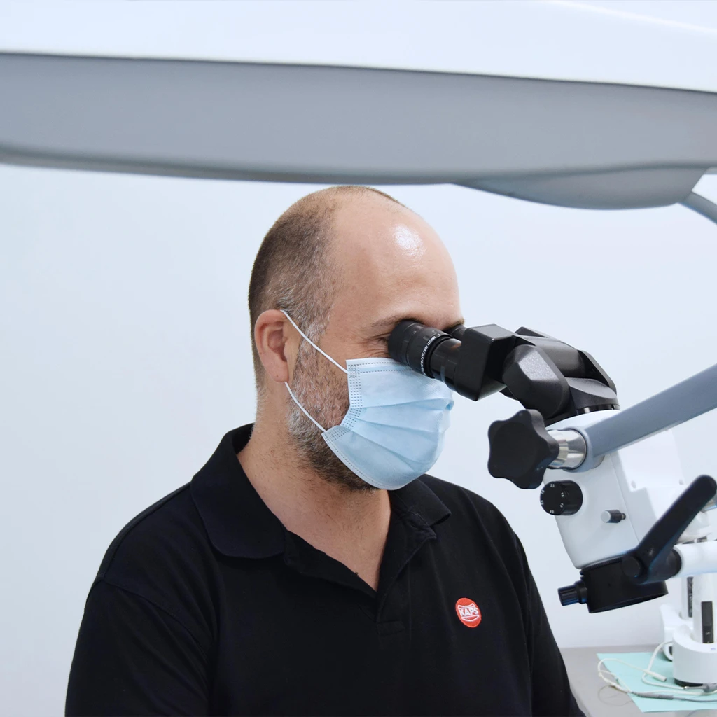 Dentista a utilizar equipamento dentário com máscara de proteção