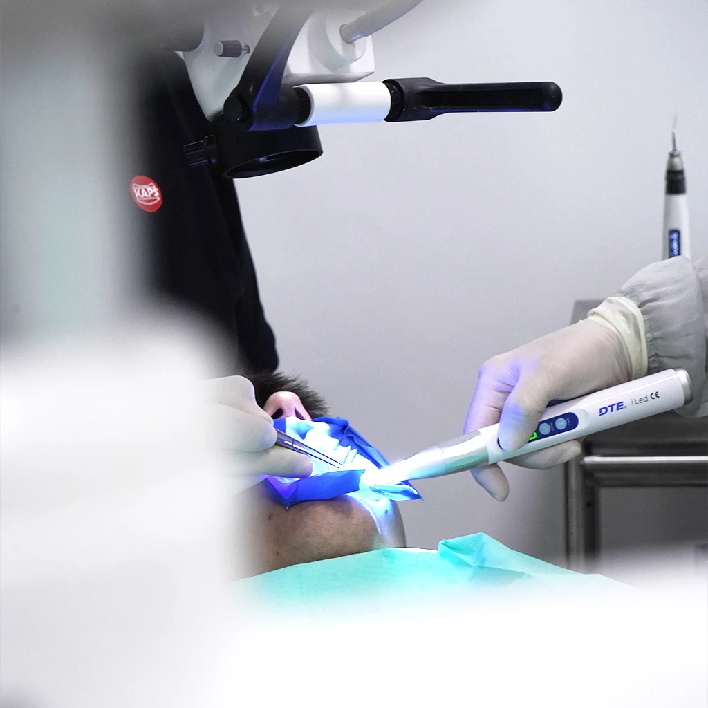 Procedimento dentário em paciente com dentista e auxiliar