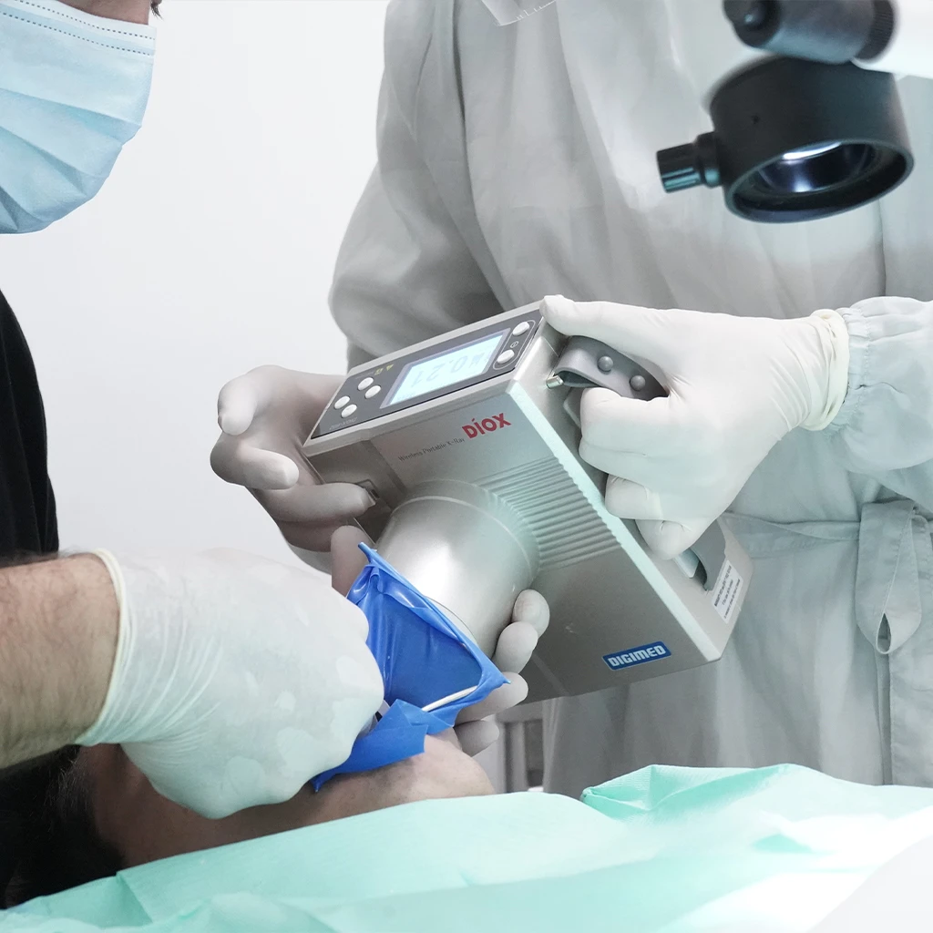 Procedimento dentário em paciente com dentista e um técnico auxiliar