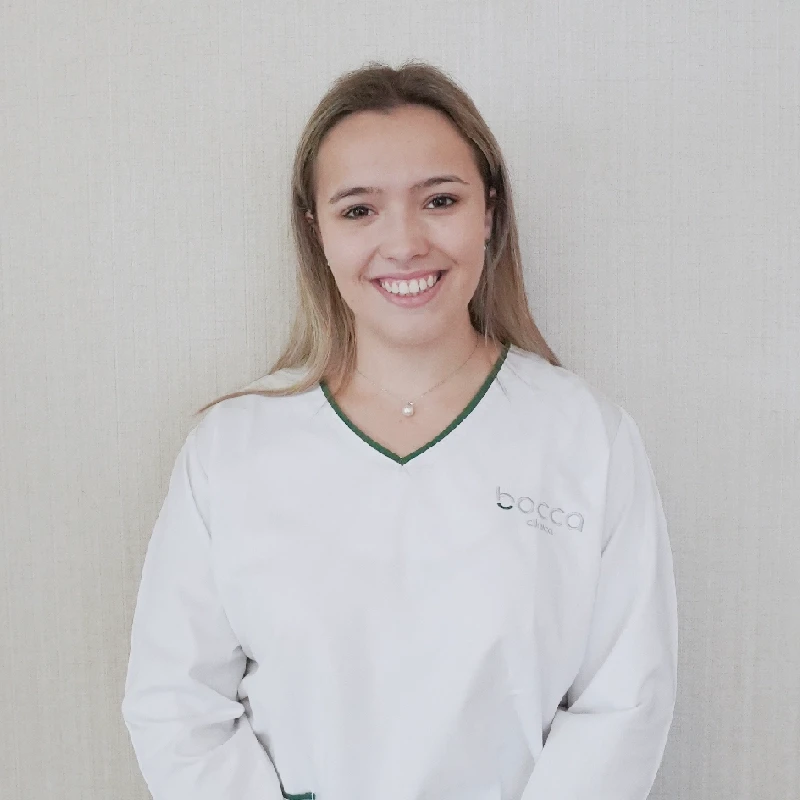 Beatriz a sorrir com fardamento clinico branco com o logo da Bocca clínica