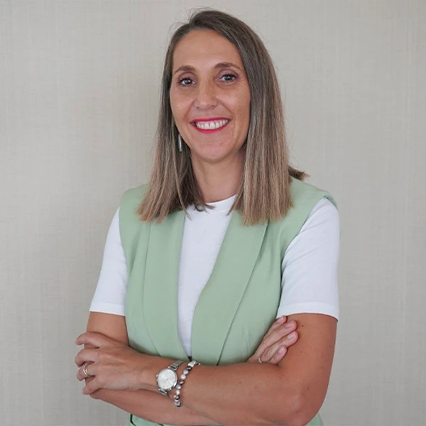 Vania Silva a sorrir com os braços cruzados, t-shirt branca e colete verde